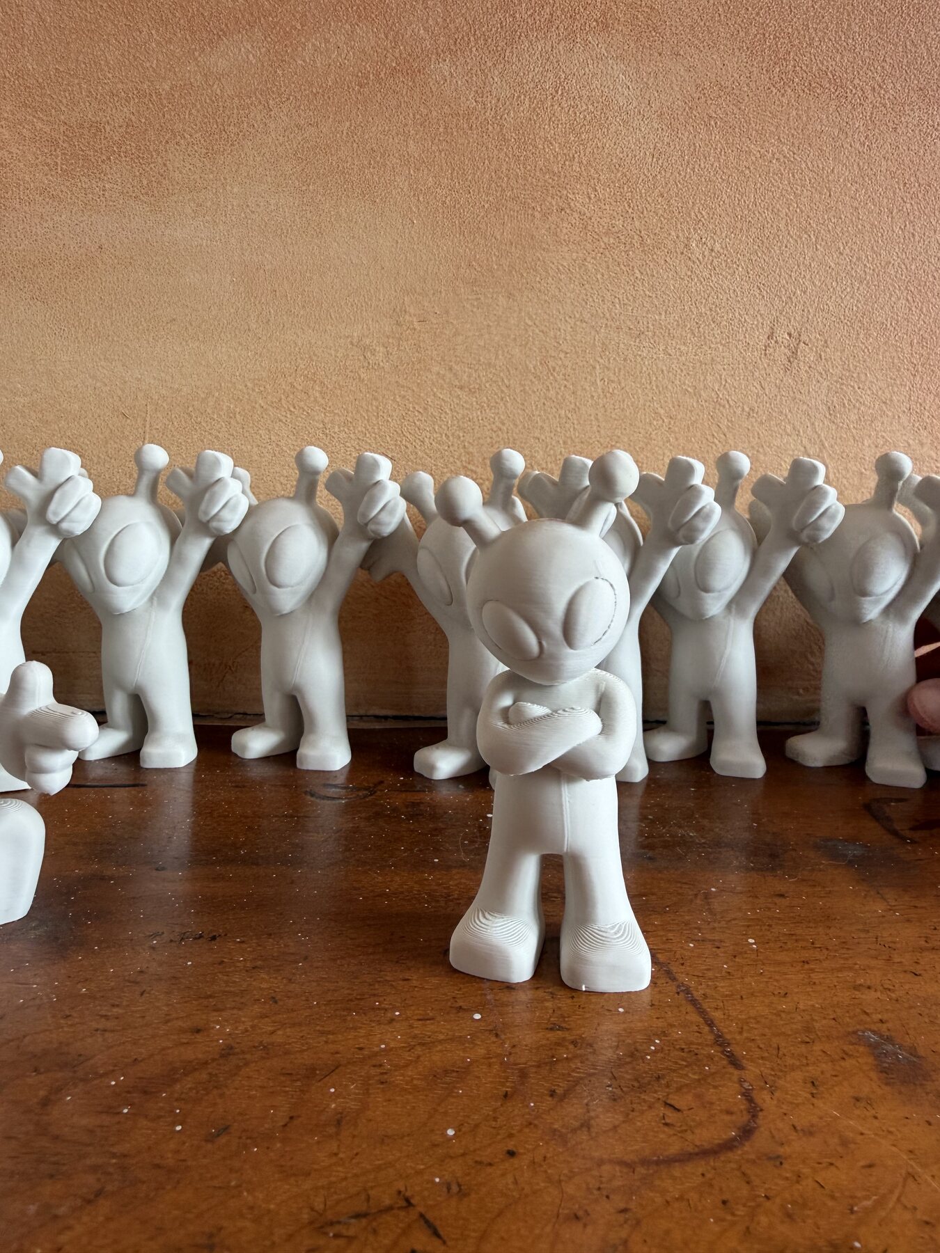 A lineup of white 3D-printed alien souvenirs for Ground Rules Festival